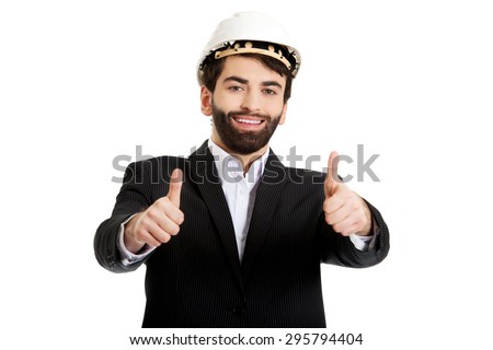Smiling businessman with hard hat showing ok sign.