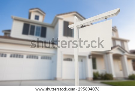 Blank Real Estate Sign in Front of Beautiful New House.