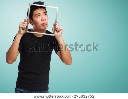young chinese man looking through a frame
