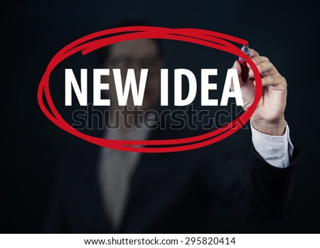 Businessman hand writing "NEW IDEA" with red marker on transparent board, Business technology and networking concept