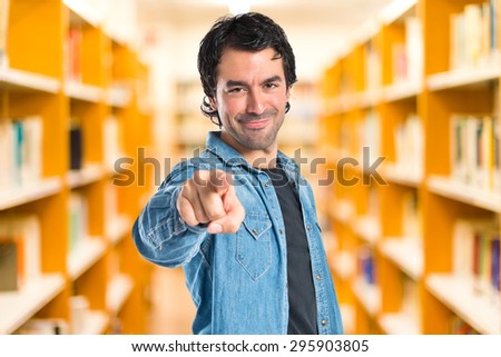 Man pointing to the front over defocused library