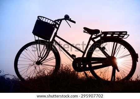 beautiful landscape image withvintage Bicycle silhouette  at sunset