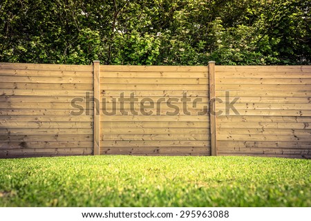 Wooden fence on a green lawn Royalty-Free Stock Photo #295963088