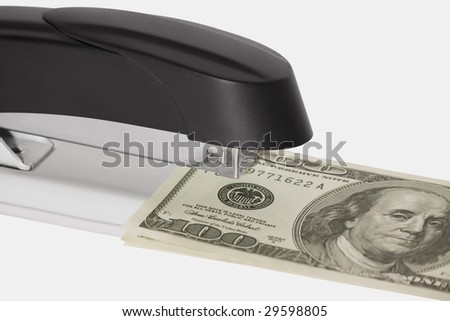 Stapler with stack of dollars isolated on white background