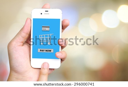 Pay now on smart phone screen in hand with blurred bokeh background, e-business concept