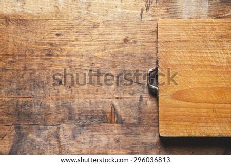 grown old wooden cutting board on a wooden old background. space for writing the text, recipes, advertising or posting menu. background for restaurants