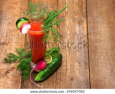 Fresh vegetable drink. Tomato juice with cucumber, radish, green onions and dill in tall glass. Wooden planks background. Copy space Royalty-Free Stock Photo #296047082