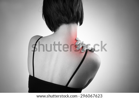 Woman with pain in shoulder. Pain in the  human body. Black and white photo with red dot