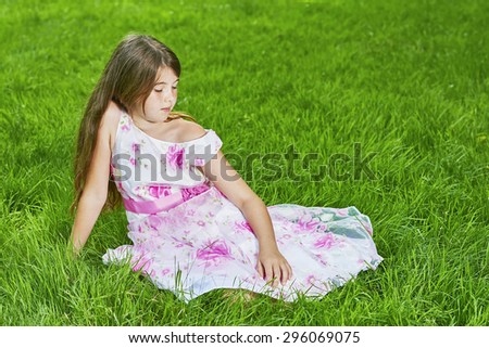 View of a young girl sitting on the grass