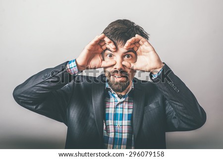 bearded businessman making binoculars hands