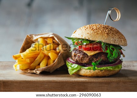 Delicious burgers with beef, tomato, cheese and lettuce Royalty-Free Stock Photo #296090063