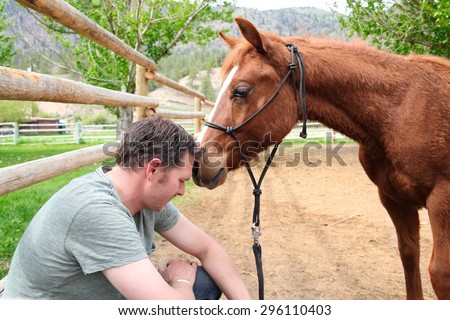 Young rancher and his trusting colt on ranch