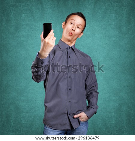 Asian man making a selfie on cell phone to social network