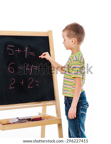 Boy standing nearby board and answering some math exercise