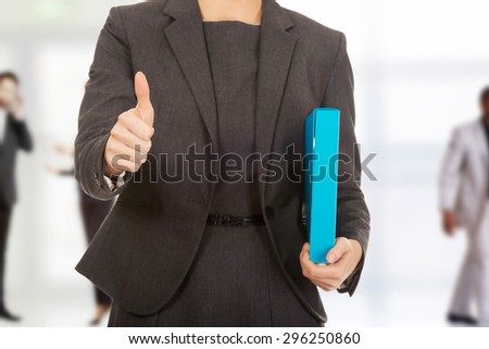 Businesswoman with thumbs up holding a binder.