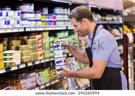 Smiling handsome taking a dairy products in supermarket