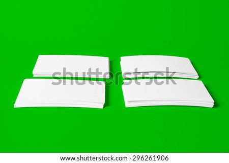 Four Piles of White Horizontal Business Cards with Clipping Path On Green Background