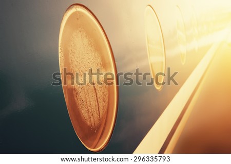 closeup porthole of flying airplane on sunset. vintage picture