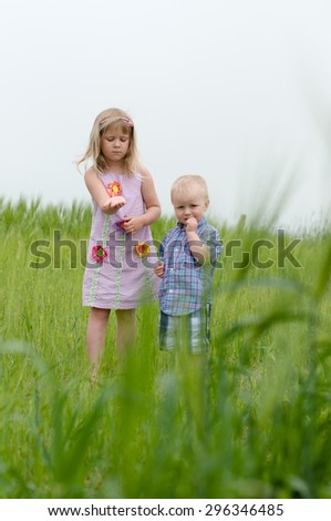 Picture of the kids is a field playing with insects