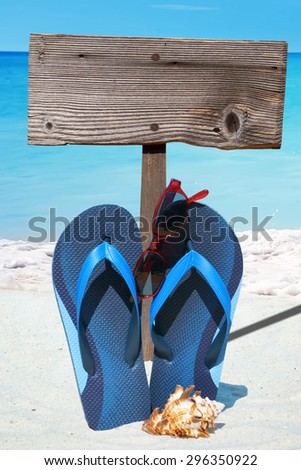 Blue Flip Flops, Sunglasses, Seashell and a wooden Signboard on the Beach