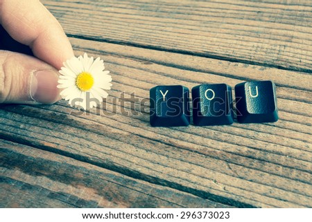 "you" wrote with keyboard keys on wooden background, vintage denim effect