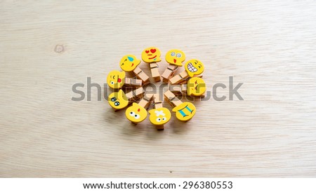Assortment of smiley faces emoticon on clothes peg on wooden surface. Concept of emotions or meta communicative pictorial representation of a facial expression. Slightly de-focused. Copy space.
