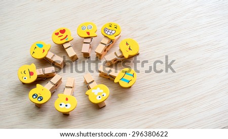 Assortment of smiley faces emoticon on clothes peg on wooden surface. Concept of emotions or meta communicative pictorial representation of a facial expression. Slightly de-focused. Copy space.