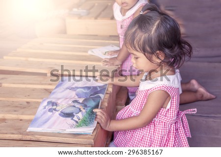 cute little girl reading books in library,vintage filter