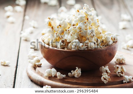 Salt popcorn on the wooden table, selective focus Royalty-Free Stock Photo #296395484
