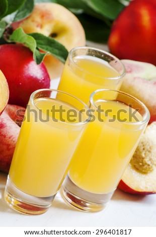 Fresh peach juice with fruits on a white wooden background, selective focus