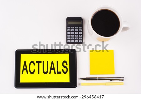 Business Term / Business Phrase on Tablet PC with a cup of coffee, Pens, Calculator, and yellow note pad on a White Background - Black Word(s) on a yellow background - Actuals