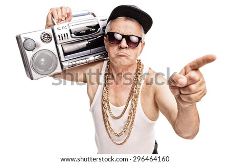 Grumpy senior rapper carrying a ghetto blaster on his shoulder and pointing with his finger isolated on white background Royalty-Free Stock Photo #296464160