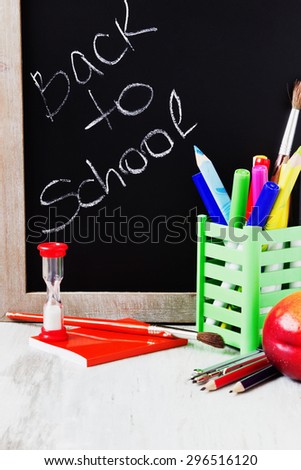 school accessories, black whiteboard and fruit on a white wooden table.  back to school concept. selective focus