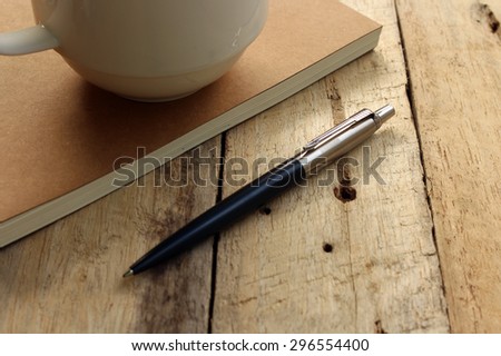 notebook with pen and coffee on old wooden table
