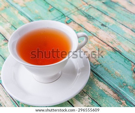 A cup of tea over weathered wooden background