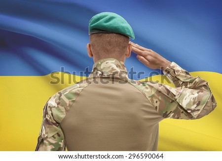 Dark-skinned soldier in hat facing national flag series - Ukraine