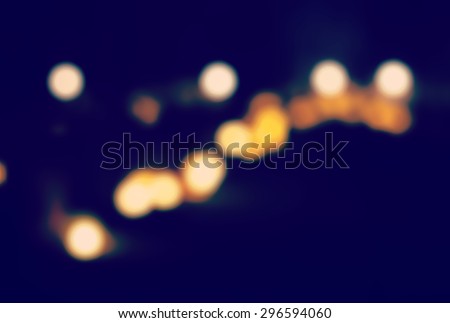 Blurry background image made of candles in the graveyard during the night. This image is suitable for example for text backgrounds, website backgrounds, or anything else. Image has a vintage effect.