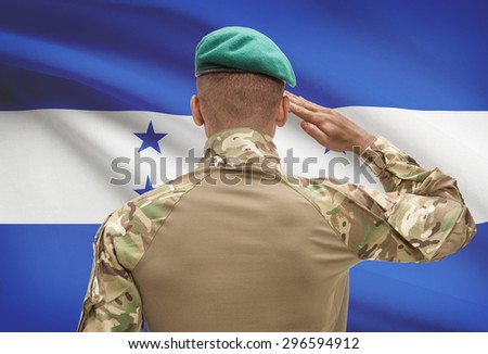 Dark-skinned soldier in hat facing national flag series - Honduras