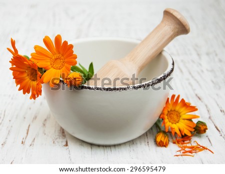flower of calendula officinalis in mortar on a wooden background