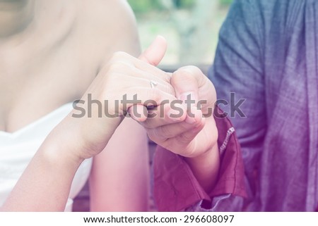 soft focus of The groom wears a wedding ring on the bride's hands. The most important of them, filter colored picture style.