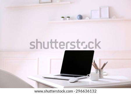Workplace with laptop in room