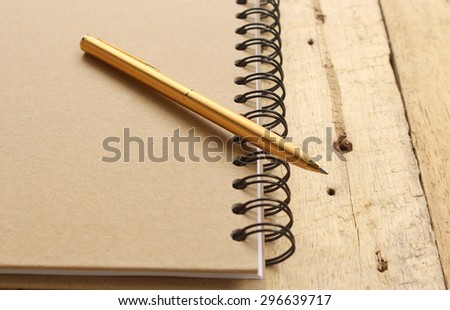 notebook and pen on wood
