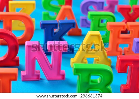 Plastic colorful alphabet letters close up on a blue background 