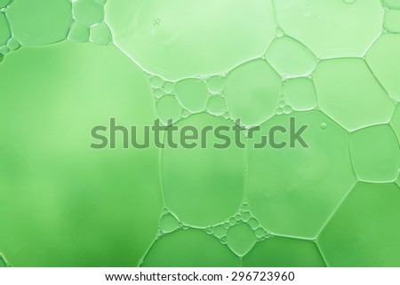 Bubble of oil and water in green background, shot with macro lens. There are many tiny bubbles inside. (Resend due Title)