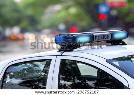 Police officer emergency service car driving street with siren light blinking  Royalty-Free Stock Photo #296752187