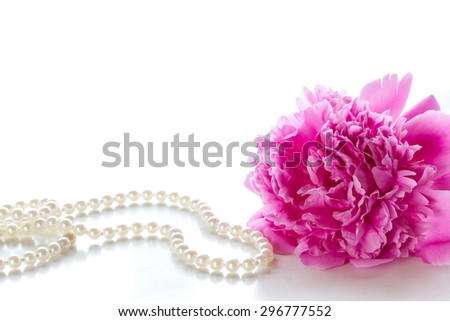 Pink peony  and a pearl necklace on a white background.