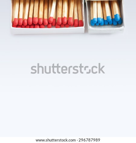 Wooden colorful matchsticks in the boxes. Red, blue matches against white background. Macro view. Copy space.