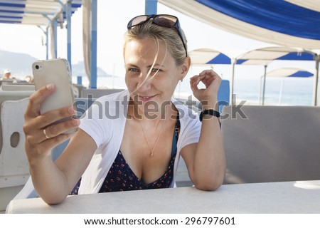 portrait of a girl with a mobile phone in a cafe on the beach.