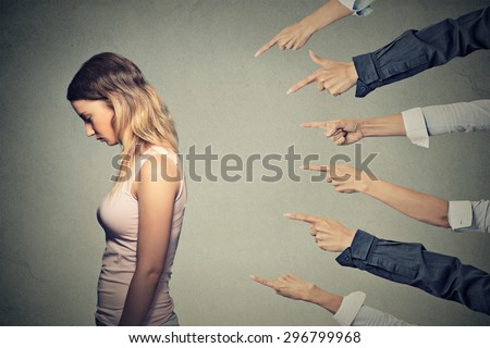 Concept of accusation guilty person girl. Side profile sad upset woman looking down many fingers pointing at her back isolated on grey office wall background. Human face expression emotion feeling Royalty-Free Stock Photo #296799968
