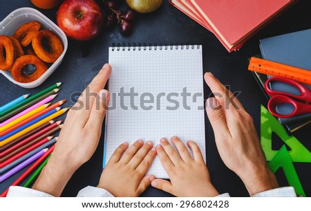 Mens and childrens hands holding a notebook. School concept. the toning. selective focus